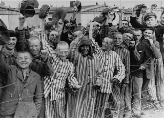 Prisoners wave at troops at the liberation of Dachau, 1945